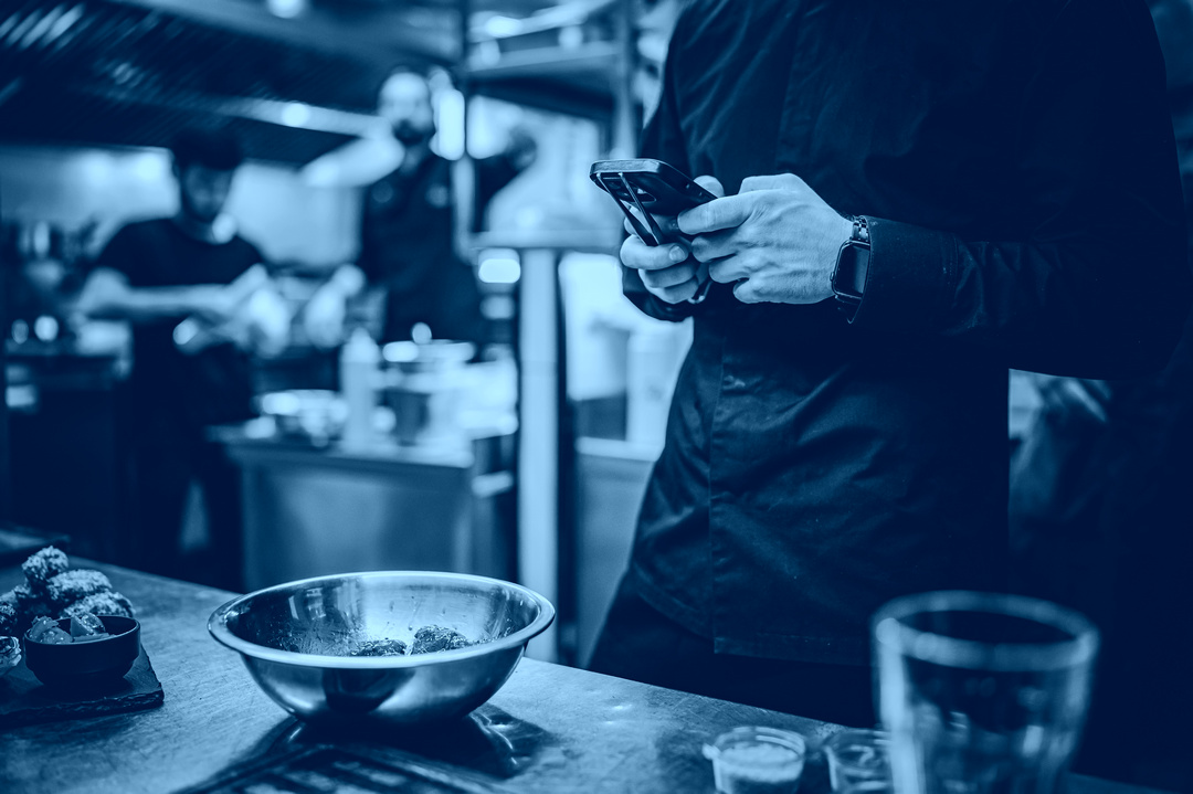 chef with phone in hands on restaurant kitchen