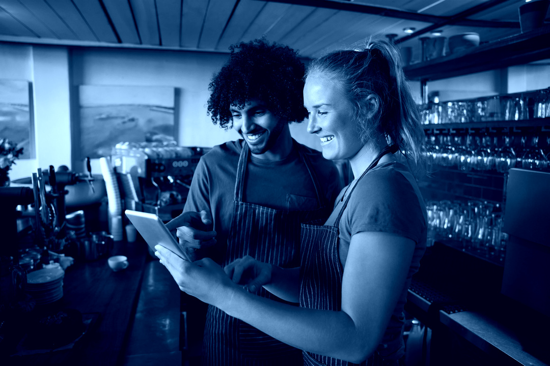 two smiling waiters with tablet device-fa3 Smiling businessma in a cafe with mobile and tablet devices