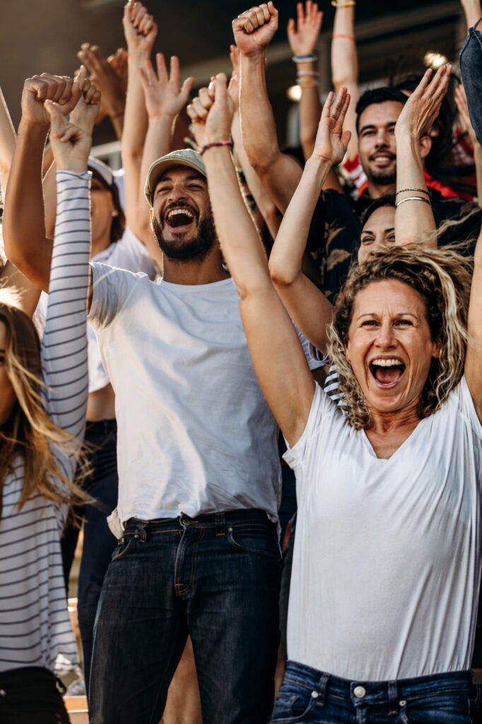 Community crowd cheering together, representing connection and mobile services that bring people closer
